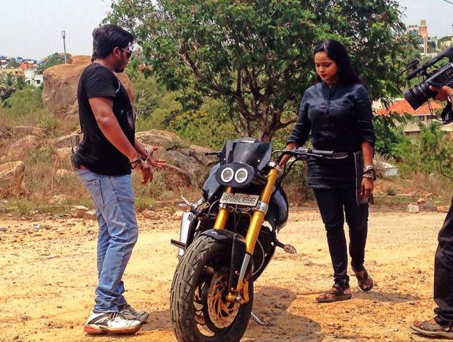 TV5 news anchor examining a custom modified motorcycle during the interview